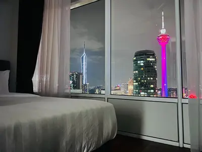 a bedroom with a view of a city skyline at Sky Suites at KLCC by Mitstay in Kuala Lumpur