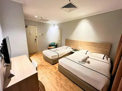a hotel room with two beds and a television at Sky Hotel Chow Kit PWTC in Kuala Lumpur