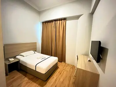 a small bedroom with a bed and a television at Sky Hotel Chow Kit PWTC in Kuala Lumpur