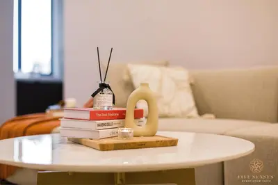 a table with books and a vase on top at The Manor Residence KLCC by Five Senses in Kuala Lumpur