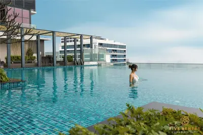 a woman standing in the water in a swimming pool at The Manor Residence KLCC by Five Senses in Kuala Lumpur