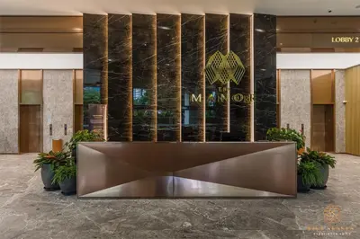 a lobby with a large bronze reception desk in front of a building at The Manor Residence KLCC by Five Senses in Kuala Lumpur