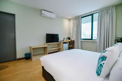a bedroom with a white bed and a television at Kingston Hotel 8 - Kuala Lumpur Bukit Bintang in Kuala Lumpur