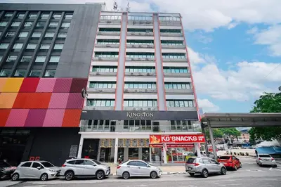 a tall building with cars parked in front of it at Kingston Hotel 8 - Kuala Lumpur Bukit Bintang in Kuala Lumpur