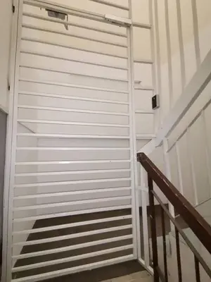 a white garage door next to a staircase at Sri Rampai Metropolitan Hostel in Kuala Lumpur