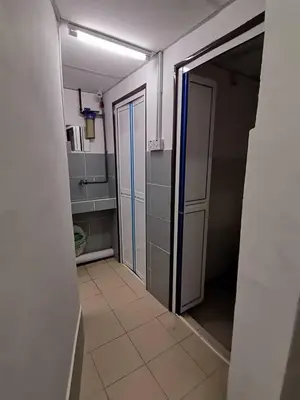 an empty kitchen with an open door to a room at Sri Rampai Metropolitan Hostel in Kuala Lumpur