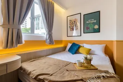 a small bedroom with a bed with a tray on it at Upstairs Downstairs CoLiving Bukit Bintang in Kuala Lumpur