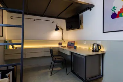 a room with a desk with a laptop on it at Upstairs Downstairs CoLiving Bukit Bintang in Kuala Lumpur