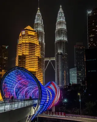 a blue lighted sculpture on a bridge in a city at night at Agile Residence TRX Bukit Bintang by Cal in Kuala Lumpur