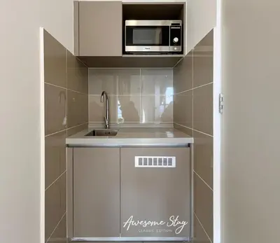 a small kitchen with a microwave and a sink at Residensi Trion in Kuala Lumpur