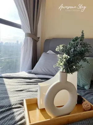 a white vase with a plant in it on a table at Residensi Trion in Kuala Lumpur