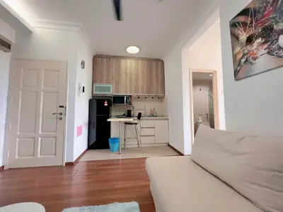 a living room with a kitchen and a white door at Comfy Studio Casa Mutiara, Near LRT Hang Tuah & Lalaport in Kuala Lumpur