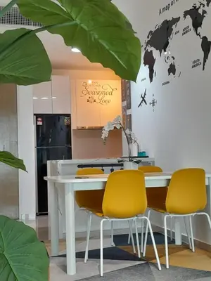 a white table with yellow chairs in a room at Badang Homestay KLCC in Kuala Lumpur