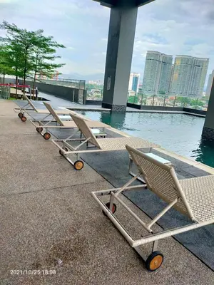 a row of lounge chairs sitting next to a body of water at Badang Homestay KLCC in Kuala Lumpur