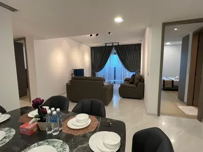 a living room with a dining table and a living room at Eaton Residence Suites KLCC in Kuala Lumpur