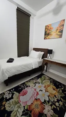 a bedroom with a bed and a flower rug at Sophia Homestay KLCC in Kuala Lumpur