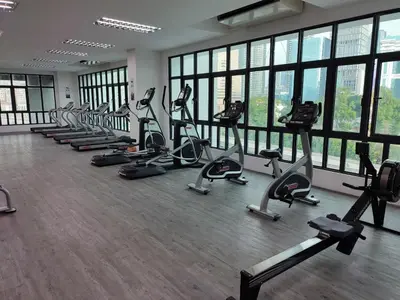 a gym with rows of tread machines in a room with windows at Sophia Homestay KLCC in Kuala Lumpur