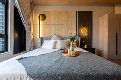 a bedroom with a large bed with a wooden headboard at Modern Design 2BR Astoria in Kuala Lumpur