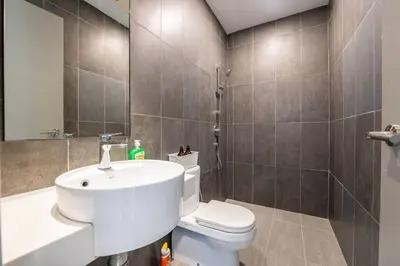 a bathroom with a white sink and a toilet at Modern Design 2BR Astoria in Kuala Lumpur