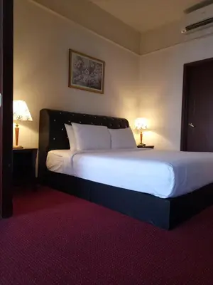 a bedroom with a bed with white sheets and two lamps at Best Apartment Suite At Times Square KL in Kuala Lumpur