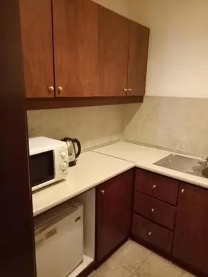 a kitchen with wooden cabinets and a white microwave at Best Apartment Suite At Times Square KL in Kuala Lumpur