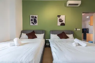 two beds in a room with green walls at The Pano by Minsu in Kuala Lumpur