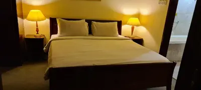a bedroom with a large bed with two lamps at Soho Service Suite at Times Square KL in Kuala Lumpur