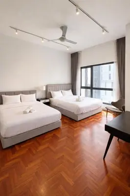two beds in a room with wooden floors at Atmoods - The Mews KLCC in Kuala Lumpur