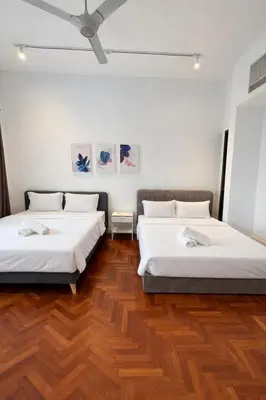 two beds in a room with wooden floors at Atmoods - The Mews KLCC in Kuala Lumpur