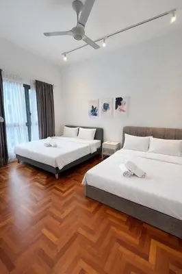 two beds in a room with wooden floors at Atmoods - The Mews KLCC in Kuala Lumpur