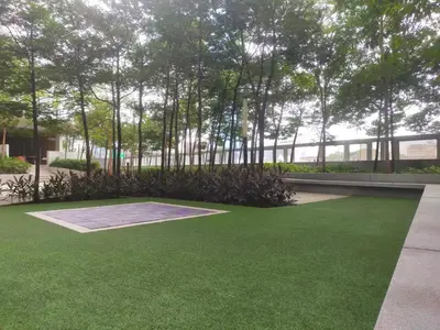 a garden with green grass and trees in front of a building at Mid Night Realm Kuala Lumpur in Kuala Lumpur