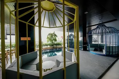a room with a bird cage next to a pool at Expressionz KLCC By Sky Homez in Kuala Lumpur