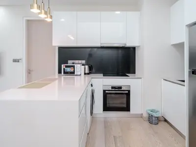 a white kitchen with white cabinets and appliances at Star KLCC Twin Tower Suite 2-3pax by DingDing in Kuala Lumpur