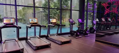 a row of treadmills in a gym with windows at Star KLCC Twin Tower Suite 2-3pax by DingDing in Kuala Lumpur