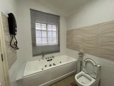 a white bathroom with a tub and a toilet at Titiwangsa Premium Villa KL by uBook in Kuala Lumpur