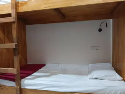 a bedroom with a bunk bed with white sheets at Monkey Mansion Signature in Kuala Lumpur