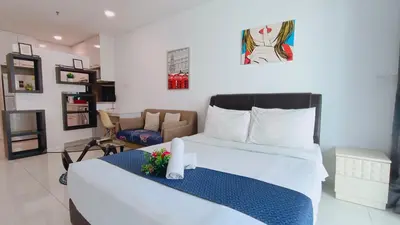a bedroom with a large white bed and a chair at Summer Suites KLCC By CityHomes in Kuala Lumpur