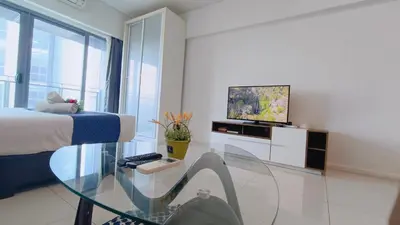 a living room with a glass table and a television at Summer Suites KLCC By CityHomes in Kuala Lumpur