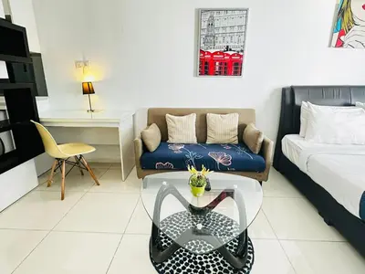 a living room with a couch and a glass table at Summer Suites KLCC By CityHomes in Kuala Lumpur
