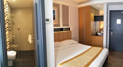 a bedroom with a bed and a shower and a toilet at Hotel Transit Kuala Lumpur in Kuala Lumpur