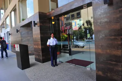 a man is standing in front of a building at Hotel Summer View in Kuala Lumpur
