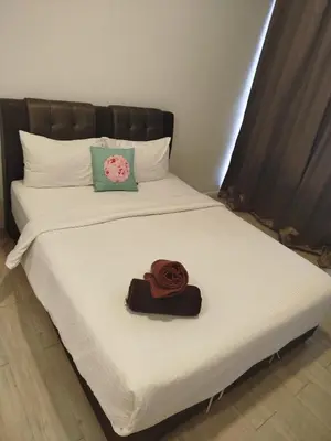 a bed with a hat and a rose on it at M City Ampang By Klcc View in Kuala Lumpur