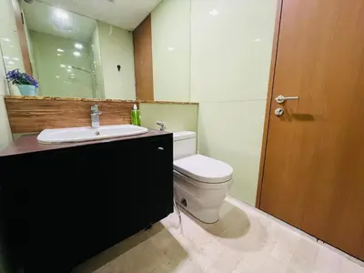 a bathroom with a toilet and a sink and a mirror at Soho Suites KLCC by DeUrban in Kuala Lumpur