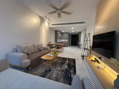 a living room with a couch and a table at Eaton Residence Klcc By Apple in Kuala Lumpur