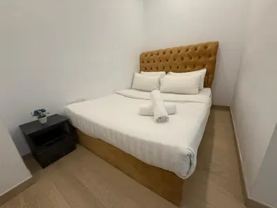 a bedroom with a large bed with white sheets at Eaton Residence Klcc By Apple in Kuala Lumpur