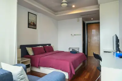 a bedroom with a bed and a couch and a tv at Couple Suite at Casa Residency 5 mins walk to LRT, Jalan Alor & Bukit Bintang in Kuala Lumpur