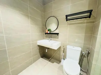 a bathroom with a toilet and a sink and a mirror at Quill Residence KL by DeUrban in Kuala Lumpur