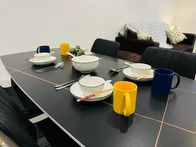 a black table with plates and utensils on it at Quill Residence KL by DeUrban in Kuala Lumpur