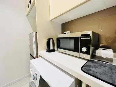 a microwave sitting on a counter in a kitchen at Quill Residence KL by DeUrban in Kuala Lumpur