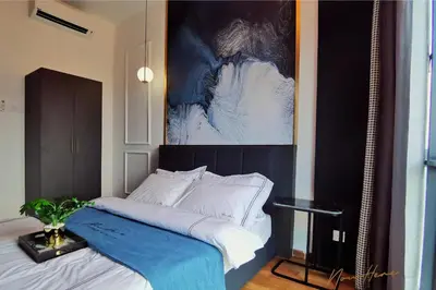 a bedroom with a bed with a painting on the wall at NowHere 2BR 4PAX with Balcony Reizz Jalan Ampang in Kuala Lumpur